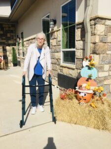 resident outside with fall decorations