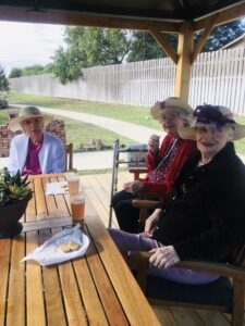 residents smiling sitting at table outside